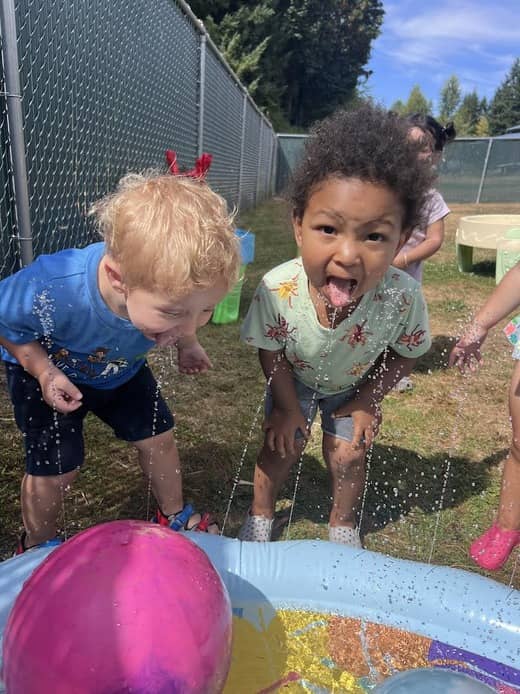 Children enjoying water play outdoors at Lil’ Patriots Academy, fostering fun learning experiences in a child care center Puyallup.