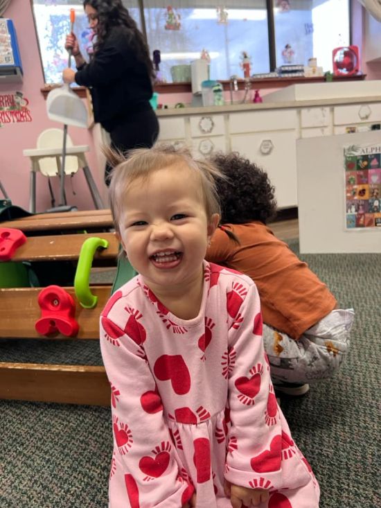 Smiling toddler in a childcare center classroom at Lil’ Patriots Academy, highlighting infant care Puyallup and nurturing caregivers.