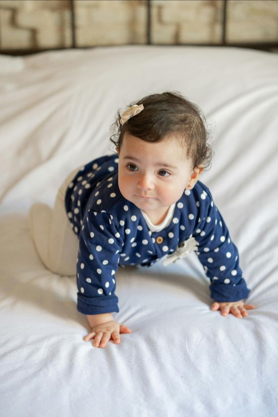Baby crawling on a soft surface in Lil’ Patriots Academy infant daycare, supported by nurturing caregivers and infant program in Puyallup.