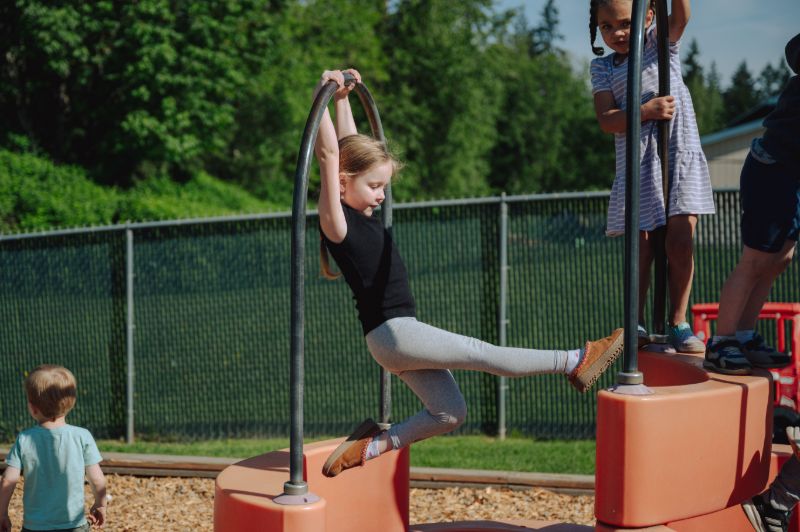 Preschooler climbing on outdoor play equipment at Lil’ Patriots Academy, highlighting access to child care subsidies and early education in Puyallup.