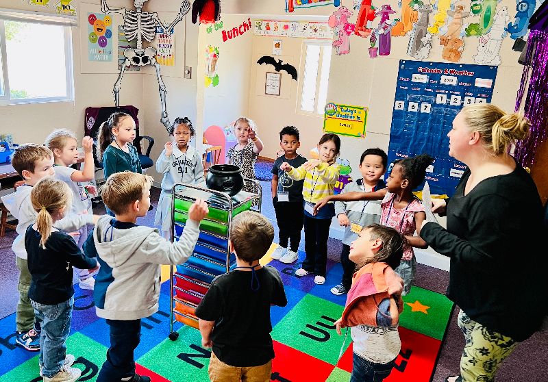 Kids and teacher enjoying circle time at a daycare in Puyallup Washington, engaging in early learning and social activities together.