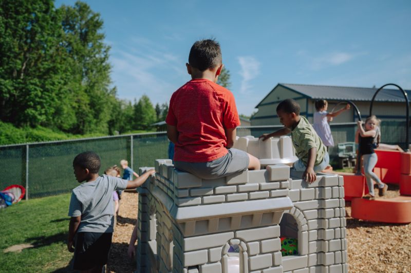 Children climbing and playing on a castle structure at Lil’ Patriots Academy, highlighting early childhood education and child care center fun.
