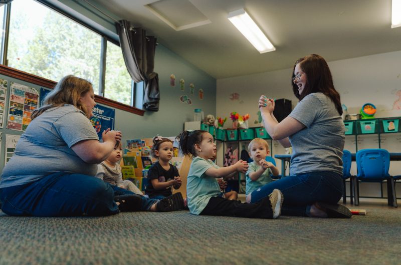 Teacher leading circle time with preschoolers at Lil’ Patriots Academy, supporting families with financial assistance for quality child care in Puyallup.