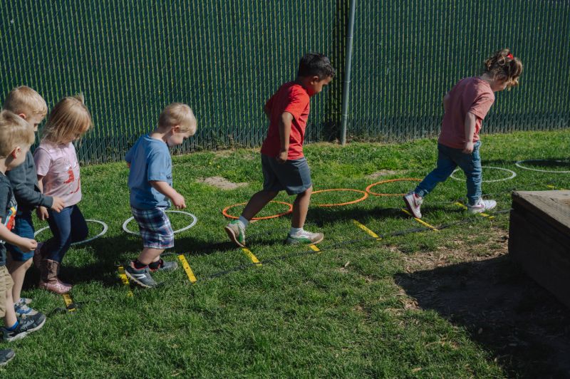 Children practicing balance and coordination with outdoor games at Lil’ Patriots Academy Kinder Prep Puyallup program.