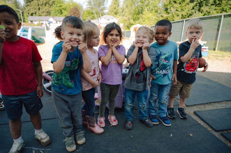 Group of children smiling together at Lil’ Patriots Academy, showing how families can access quality child care with subsidies in Puyallup.