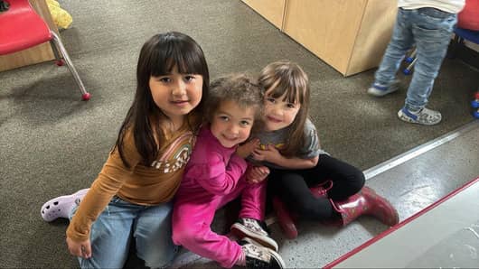 Three preschool friends smiling together at Lil’ Patriots Academy, showcasing the nurturing Pre-K Academy and kindergarten readiness program in Puyallup.