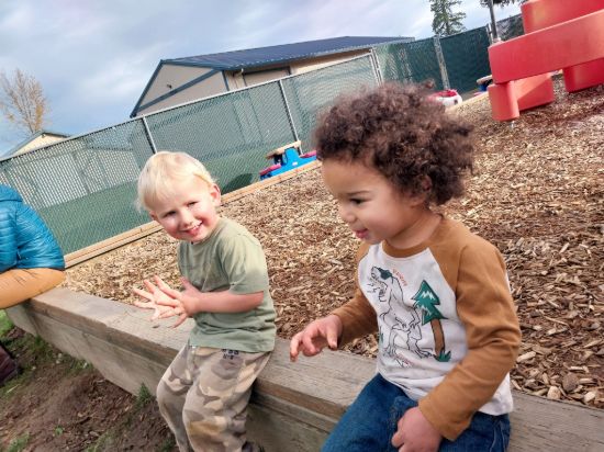Two preschool children collaborating on a classroom activity at Lil Patriots Academy 56th Ave campus.