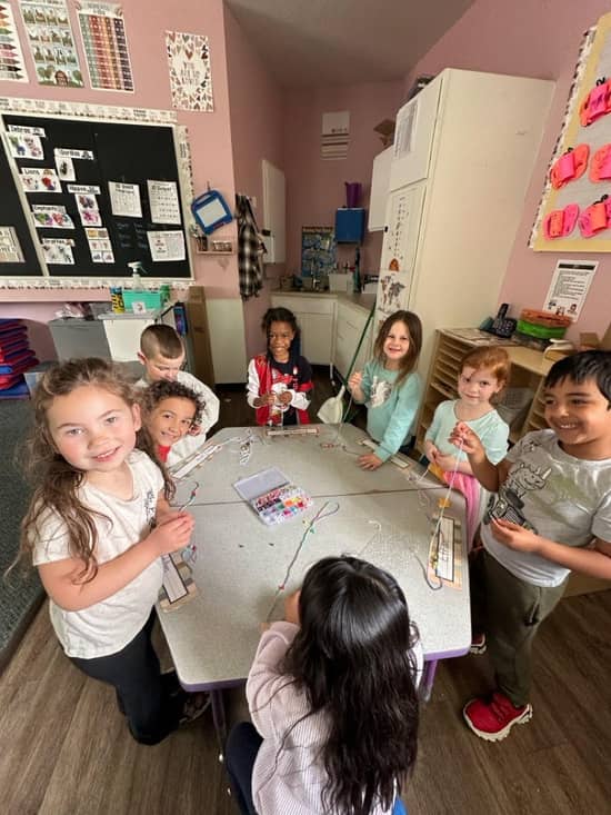 Teacher engaging with toddlers at Lil Patriots Academy in Puyallup, demonstrating hands-on childcare puyallup wa instruction and care.